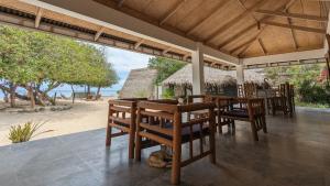a restaurant with tables and chairs on the beach at Safira Resort in Santa Fe
