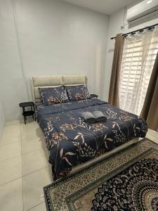 a bedroom with a bed with a blue comforter at Khaeel Homestay in Ipoh