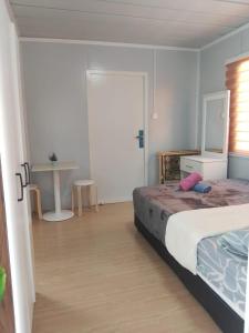 a bedroom with a bed and a table in it at K2K Studio Homestay in Ranau