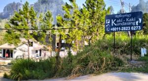a sign on the side of a road with trees at K2K Studio Homestay in Ranau