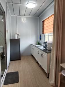 a kitchen with a sink and a microwave in it at K2K Studio Homestay in Ranau
