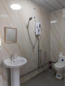 a bathroom with a shower and a sink and a toilet at K2K Studio Homestay in Ranau