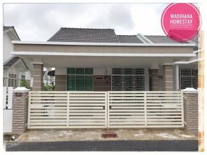 a house with a white fence in front of it at Wadihana Homestay in Kangar