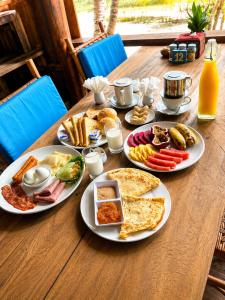 a wooden table with plates of breakfast food on it at Salacia's Suite in Koh Rong Island