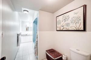 a bathroom with a toilet and a picture on the wall at Butterfly Manor in Niagara Falls +66 photos
