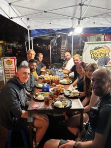 a group of people sitting around a table eating food at Base Seven Hostel in Bandung +21 photos