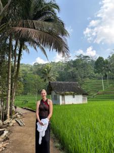 a woman standing in front of a rice field at Base Seven Hostel in Bandung