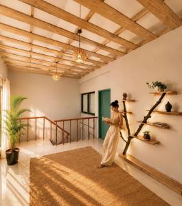 a woman standing in a living room with a tree at Chetan's Villa in Bhīm Tāl