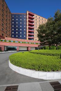 a large building with a green hedge in front of a building at ホテルKOYO in Hashima
