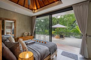 a bedroom with a bed and a large window at San Michele Villa in Dalung +32 photos
