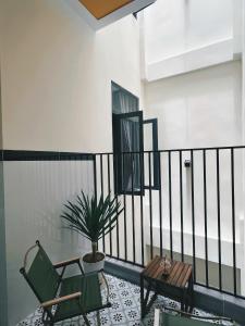 a balcony with a chair and a table and a potted plant at TRI'S Homestay in Quy Nhon