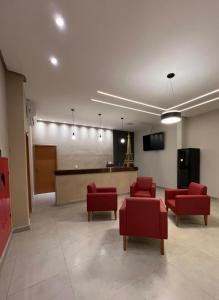 a waiting room with red chairs and a chalkboard at Hotel Paris in Balsas