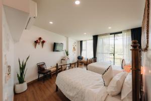 a bedroom with two beds and a window at Pupah Kanna Pua-ปู๋ ป๋าล์ คันนา ปัว in Pua
