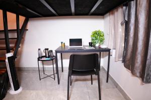 a desk with a laptop and a chair in a room at Eden Park Resorts in Vuyyūru