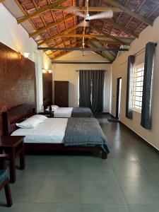 a bedroom with two beds and a ceiling at Sky Holiday Homestay Cottages Madikeri Kushalnagar Coorg in Kushālnagar