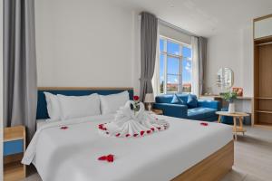 a bedroom with a large white bed and a blue couch at Vorya Hotel Danang Beach in Danang +36 photos