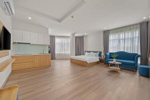 a living room with a couch and a bed and a kitchen at Vorya Hotel Danang Beach in Danang