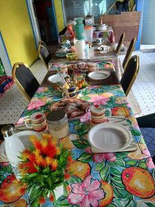 a table with plates of food and flowers on it at Salote homestay in Lautoka