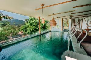 a swimming pool in a house with blue water at Pupah Kanna Pua-ปู๋ ป๋าล์ คันนา ปัว in Pua