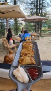 a tray of food on a table with ketchup at Alex Tribe Cafe and Funstay in Sainj +33 photos