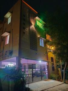 a building with a garage at night with lights at Vihaasam Homestay in Thanjāvūr