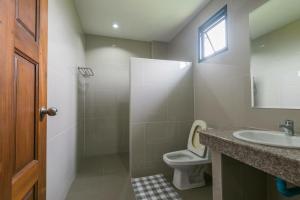 a bathroom with a toilet and a sink and a mirror at Tha-ruea Residence in Thalang +8 photos
