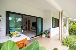 a living room with a table and some plants at Bang Po Hut Nature - Lush Garden & Natural View in Ban Bang Po