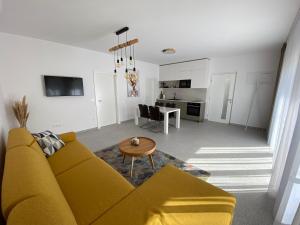 a living room with a yellow couch and a table at Apartmany Vir DaRa in Vir