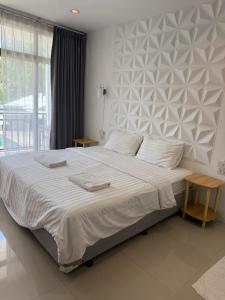 a bedroom with a large bed with white sheets at Malina Guesthouse in Ko Phangan