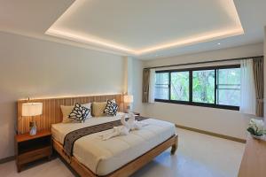a bedroom with a bed and a large window at Bang Po Hut Nature - Lush Garden & Natural View in Ban Bang Po