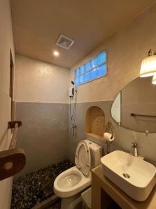 a bathroom with a toilet and a sink at Kundiman Siargao, General Luna in General Luna