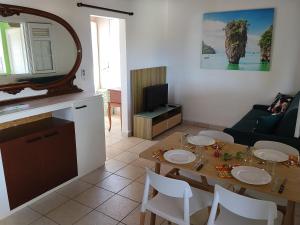 a living room with a table with chairs and a television at Kaza LYBS in Fort-de-France