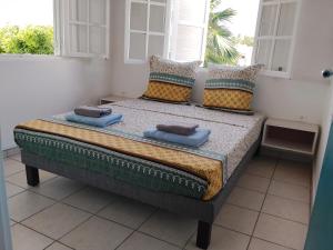 a bed sitting in a room with a window at Kaza LYBS in Fort-de-France
