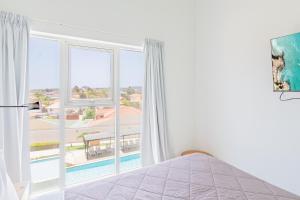 a bedroom with a bed and a large window at Aruba Life 315 in Noord +13 photos