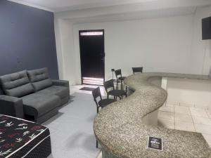 a living room with a couch and a table at Maia Hostel in Várzea Grande