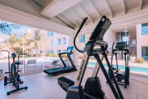 a gym with treadmills and a swimming pool at Aruba Life 315 in Noord