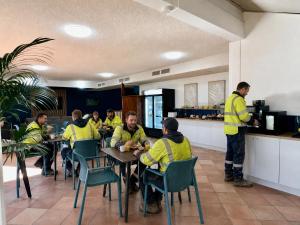 a group of men in yellow jackets sitting at tables in a restaurant at Sails Motel Geraldton in Geraldton +23 photos