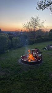 a fire pit with a bench in the grass at Landhausvilla Watzmannblick in Saaldorf-Surheim