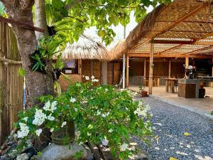 a house with a tree and flowers in front of it at LAWI Haven Homestay with Dorm in Burgos