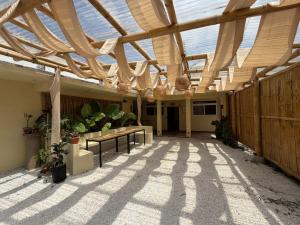 a conservatory with a wooden roof with plants and benches at Zu Suites in San Marcos La Laguna