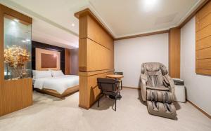 a hotel room with a bed and a chair at Nowon Luxe in Seoul