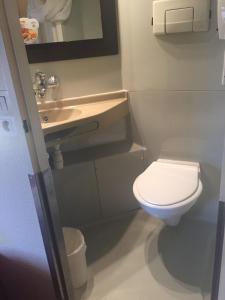 a small bathroom with a toilet and a sink at Premiere Classe Grenoble Sud - Gieres Universite in Gières