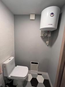 a bathroom with a white toilet and a water tank at Shells & Pines in Jūrmala