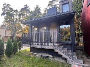 a small house with a porch and stairs in a yard at Shells & Pines in Jūrmala +5 photos