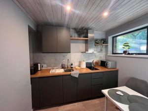 a kitchen with brown cabinets and a sink and a window at Shells & Pines in Jūrmala