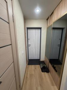 a hallway with two doors and a wooden floor at Harmony Apartments Lux in Liepāja