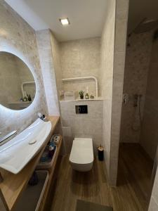 a bathroom with a toilet and a sink and a mirror at Harmony Apartments Lux in Liepāja +8 photos