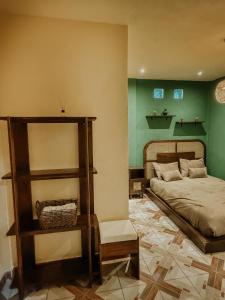 a bedroom with a bed and a green wall at Zu Suites in San Marcos La Laguna