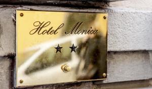 een bord op een stenen muur met een hotel americoria bij Hotel Monica in Florence