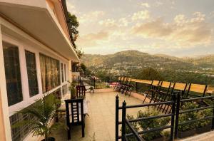 a balcony with chairs and a view of the mountains at Chetan's Villa in Bhīm Tāl